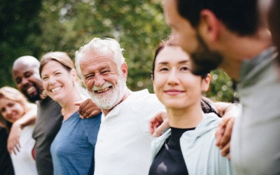 Line of people with arms linked smiling at one another