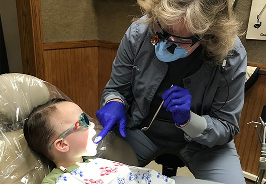 Dental team member providing dental services for child
