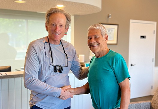 Dentist shaking hands with dental patient