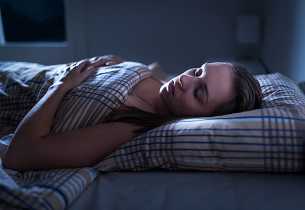 Woman with sleep apnea in Warsaw, IN lying in bed snoring