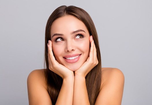 a woman holding her face and smiling