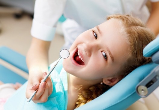 Child receiving dental checkup and teeth cleaning