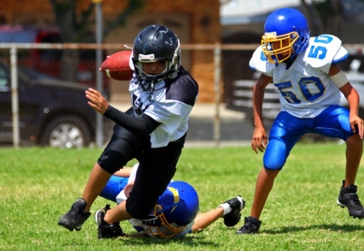 Teens playing football with athletic mouthguards