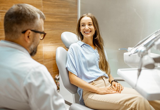 Smiling patient talking to dentist in treatment room