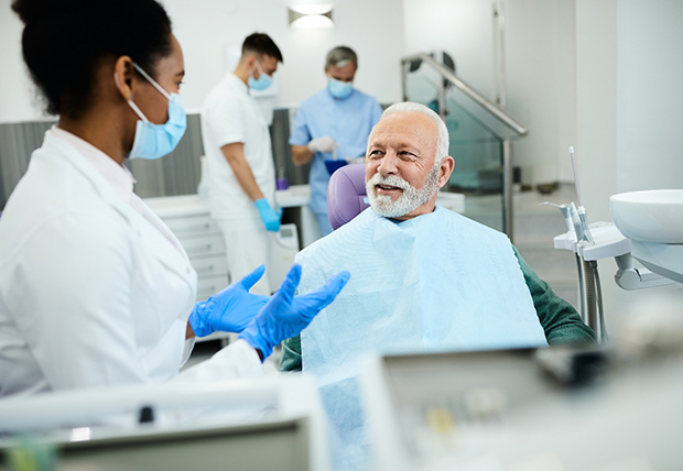 happy man talking to dentist about dental implants in Warsaw 