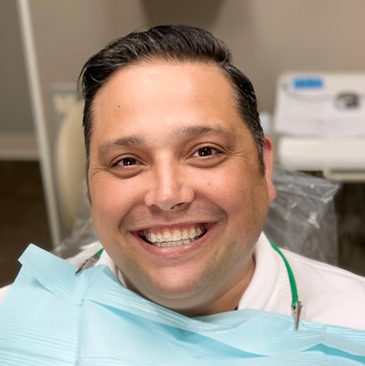 Man wearing Invisalign trays smiling in dental chair in Warsaw