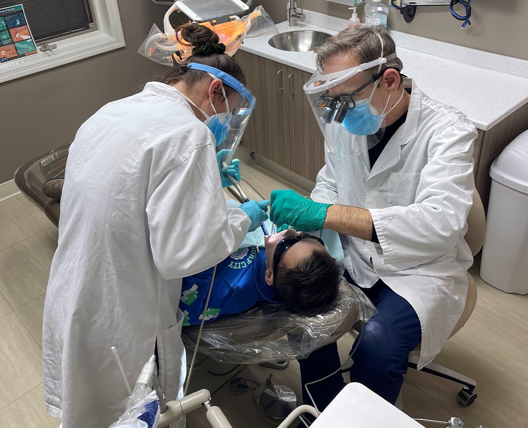 Dentist and dental team member treating dental patient in Warsaw