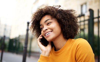 Smiling woman talking on phone outside