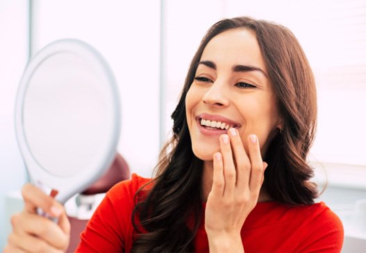 A woman admiring her new dental implants