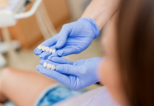 Dentist showing patient two different dental bridges