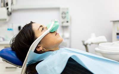 Woman in dental chair with nitrous oxide mask over nose