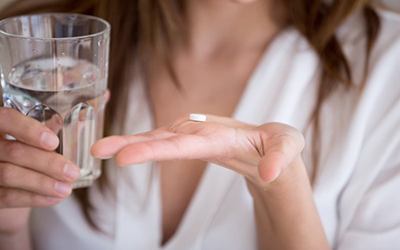 Lady prepares to take pill with water