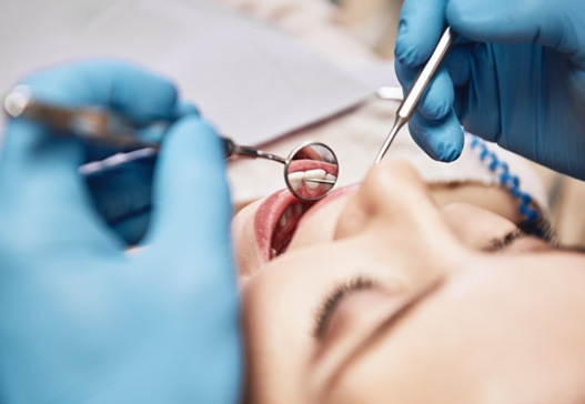 Dentist examining a patient’s teeth and gums