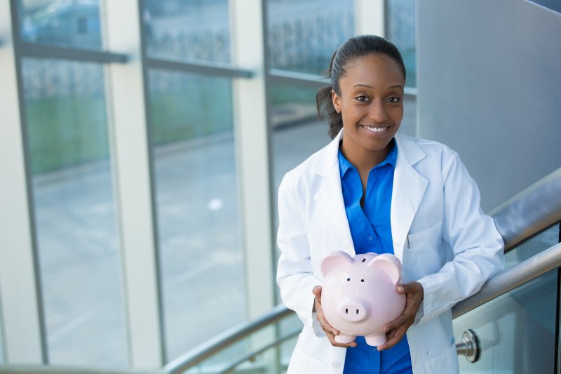 A dentist in Warsaw holding a piggy bank