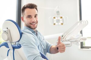 Man smiling after getting his dental crown reattached
