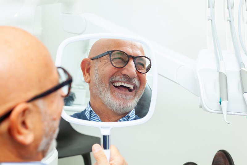 older man smiling with his new dental implants