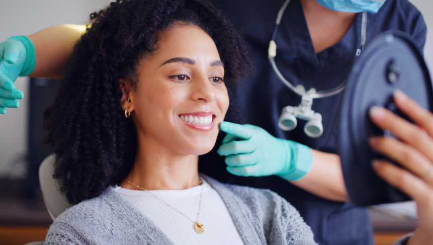 Dentist showing smiling woman a mirror