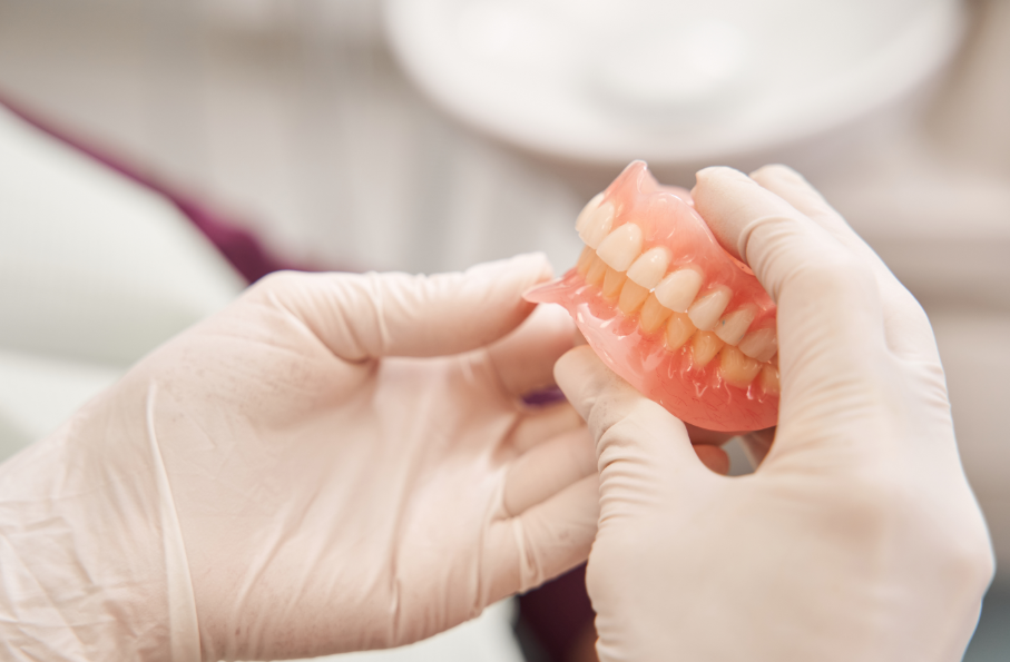 Close up of dentist's hands holding dentures